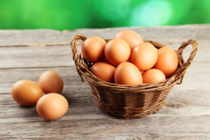 41530509 - chicken eggs in basket on grey wooden background